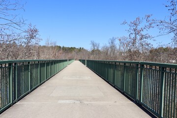 The long pathway bridge in the park on a sunny day.