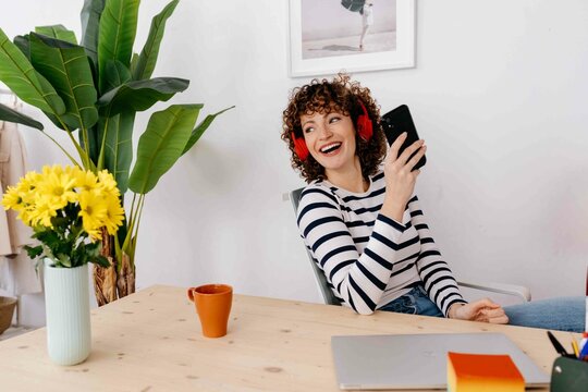 Happy woman with smartphone smiling in office
