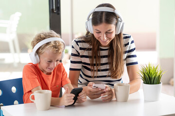 Mother and son, interacting amusingly with their mobile phones