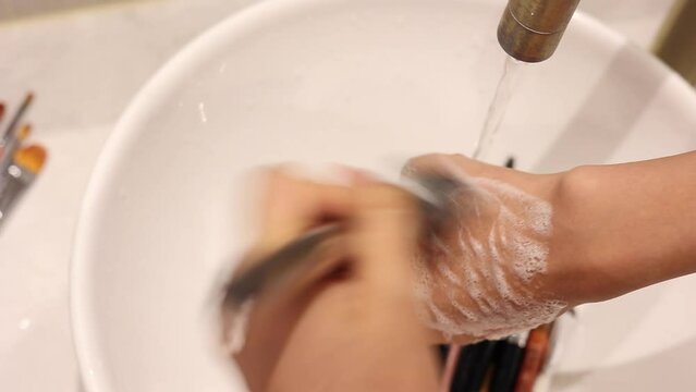 Cleaning makeup brushes, washing makeup tools.