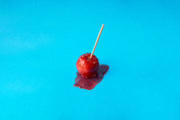 Delicious sugar candy caramel apple on a blue  background