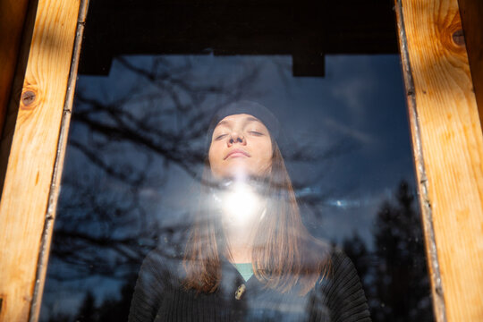 Woman soaking up the sun through the window