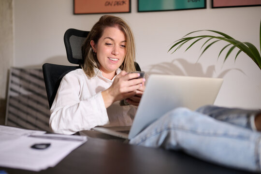 Efficient Multi-Tasking: Businesswoman with Laptop and Smartphone