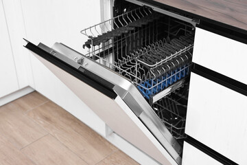 Built-in dishwasher with open door indoors. Home appliance