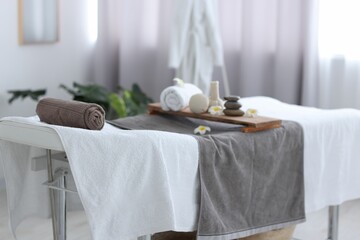 Rolled towel and spa products on massage table in recreational center