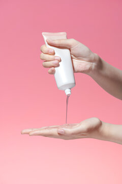 Woman's hand squeezing white moisturizing cream