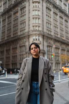 Young woman in a vintage coat staring at the camera. 