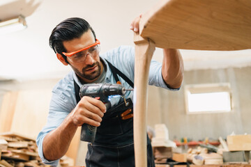 Carpenter working with electric planer on wooden plank in workshop. Craftsman makes own successful small business, man using tool in carpenter's shop to making a furniture from wood