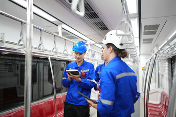 Apprentices engineer checking inside the skytrain at railway engineering facility.