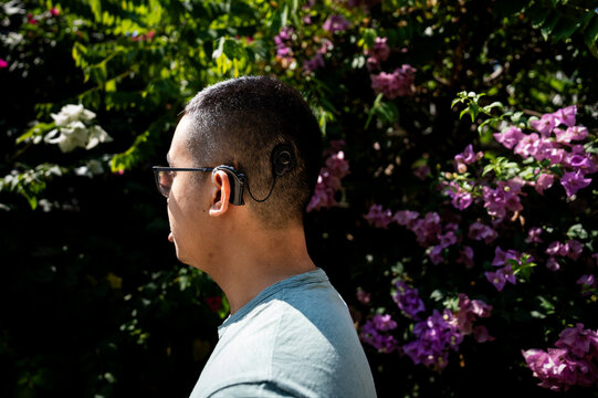 A profile of a Gen Z person with a cochlear implant outside 