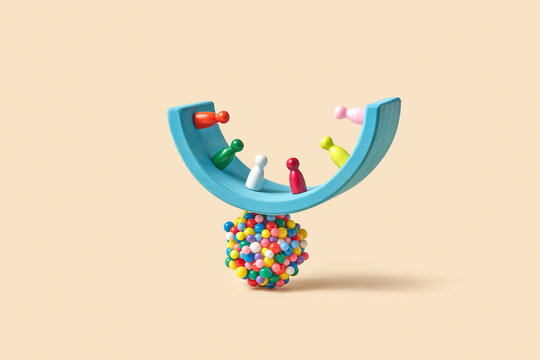 Blue wooden arch with game pawns balancing on sphere made of balls