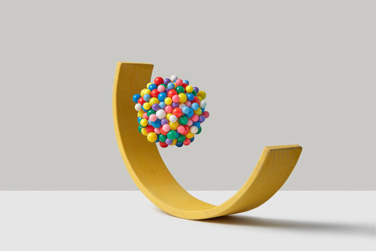 Rounded yellow wooden plank with levitating colorful sphere