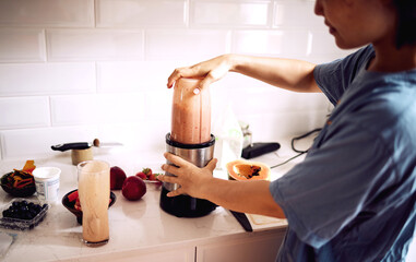 Woman, fruit and smoothie in kitchen with blender for healthy breakfast, morning routine and body...