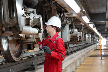 Professional technician worker hold light tube to check and maintenance part of train in electrical or metro train factory.