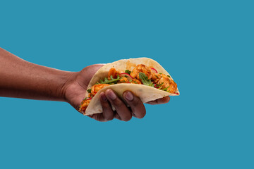 Hand holding shrimp taco.