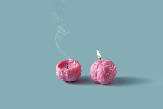 Pink burning and blown out candles in form of human brain in studio