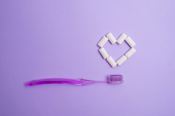 Toothbrush and chewing gum lie on a colored background. Time to brush your teeth. Top view, flat...