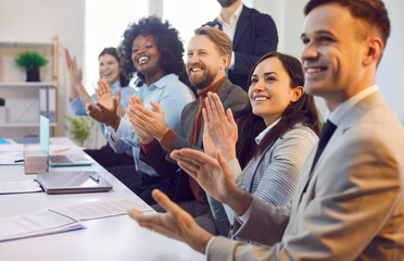 Diverse crowd of business people applauds together at an office meeting event, celebrating success. This business team showing group teamwork and achievement in a professional work environment.