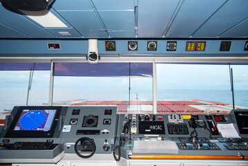 View of the control console on the navigational bridge of the cargo container ship. 