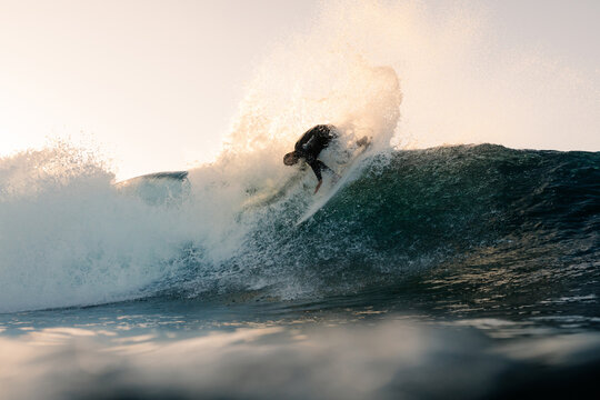 An underwater camera captures a professional surfer executing a trick