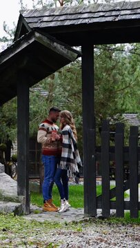 Couple in love in the countryside. Date of a romantic couple near the wooden gate of the cottage in autumn time. Vertical video