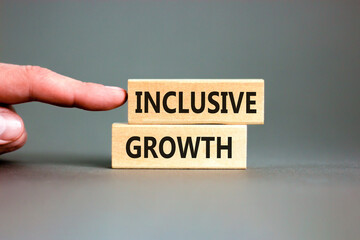 Inclusive growth symbol. Concept words Inclusive growth on beautiful wooden blocks. Beautiful grey table grey background. Businessman hand. Business inclusive growth concept. Copy space.