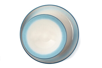overhead view of a blue soup bowl on a blue dinner plate isolated on white
