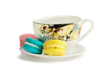 macaroon cookies with a colorful teacup on a white background