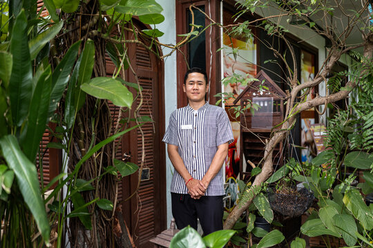 Thai man posing outdoors in garden.