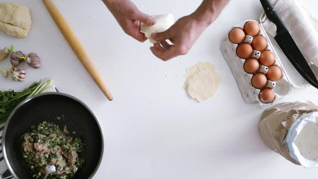 Cooking homemade dumplings, chinese dumplings with meat on a wooden table and ingredients for cooking. 