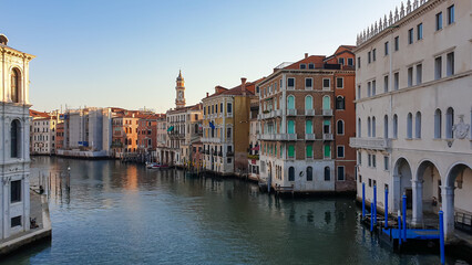 Scenic sunset view of Grand Canal in city of Venice, Veneto, Italy, Europe. Famous landmarks along  ater traffic corridor Grand Canale. Urban tourism in summer. Soft light shining on historic building - obrazy, fototapety, plakaty