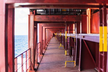 Cargo container ship deck walkway, under loaded containers with cargo. Crew walkway. Tunnel...