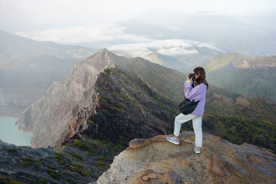 Female Travel Capturing Mountains and Misty Landscape at Dawn