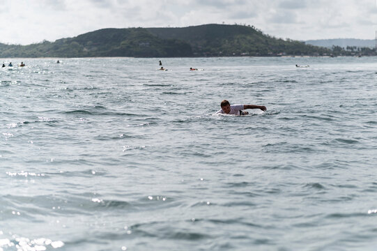 Surfer paddles in tropical waters in Indonesia