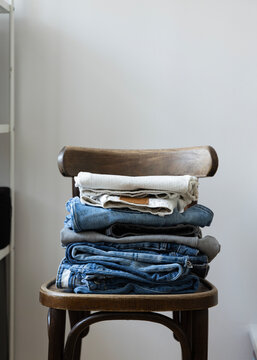 stack of folded pants on a chair 