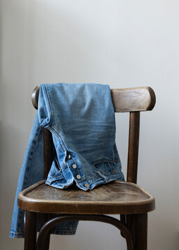 pair of pants hang on a wooden chair 
