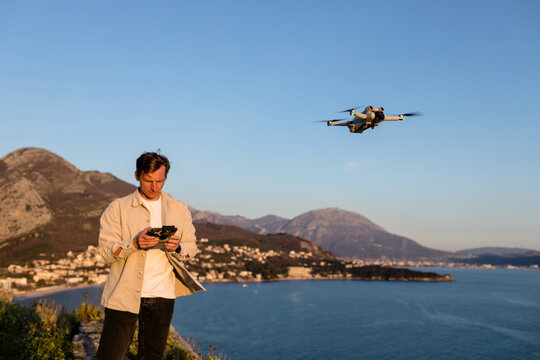 Man operates quadcopter above the sea