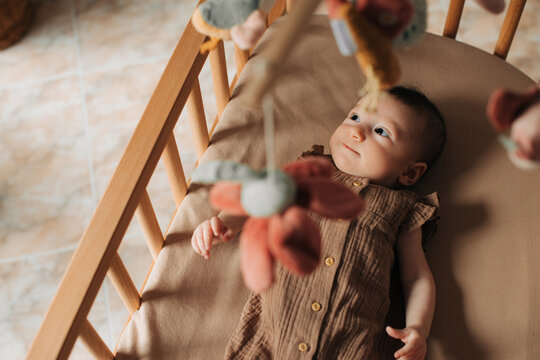 Baby in a crib looking at mobile