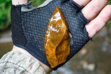 Leaf-shaped flint spearhead found in a stream, ancient stone age artifact in hand