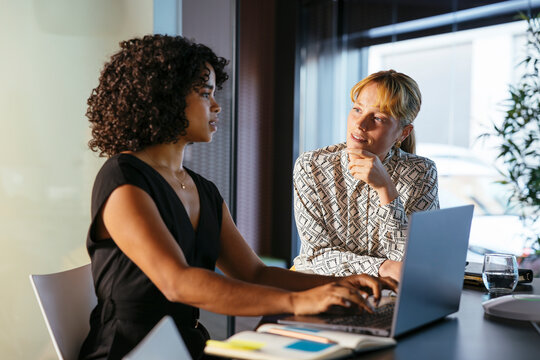 Focused female lawyers working on laptop in office