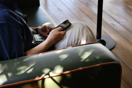 Asian man checking his mobile phone in relaxing space