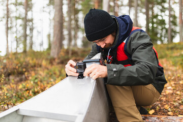 Man attaching action camera to kayak in wilderness adventure
