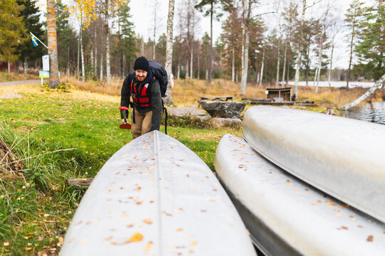 Happy man with kayak looking to camera in wilderness adventure
