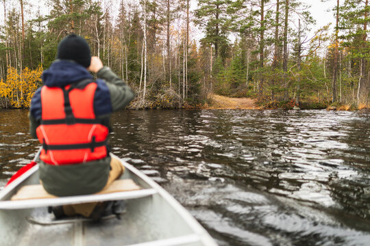 Young man rowing a kayak on a forest Lake