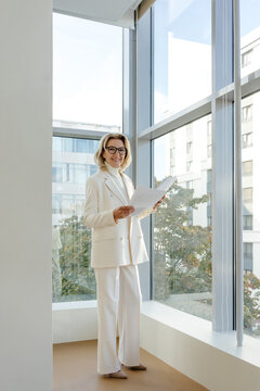 Mature female professional with documents in office