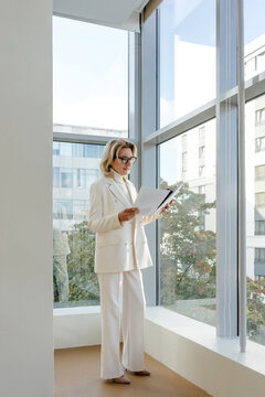 Female boss reviewing documents in light office