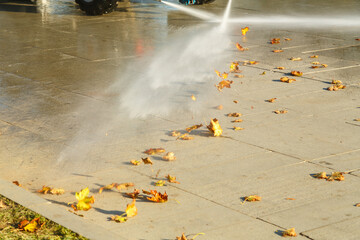 Watering streets and sidewalks using special equipment to wash away dust and leave