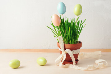 Green grass in a pot and Easter colored eggs.