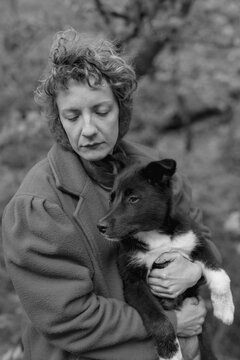 black and white portrait of a woman and a black puppy