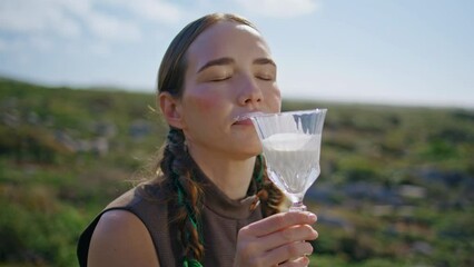 Woman drinking fresh milk on outdoor picnic. Closeup happy model enjoying dairy